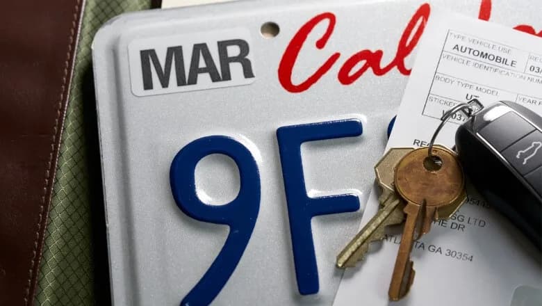 A license plate with a registration sticker, car keys and a registration form