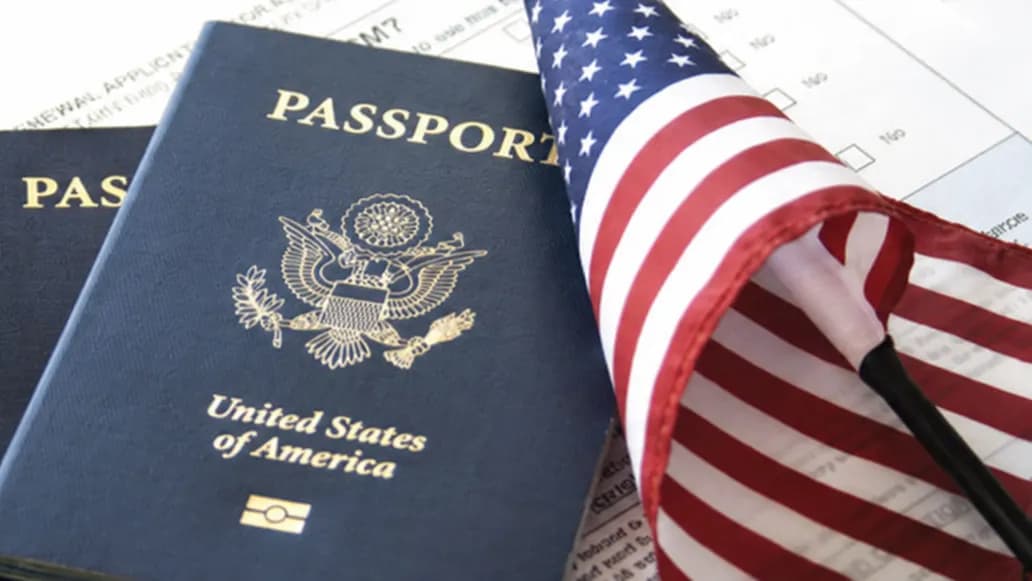 Two passports and a small American flag resting on application forms