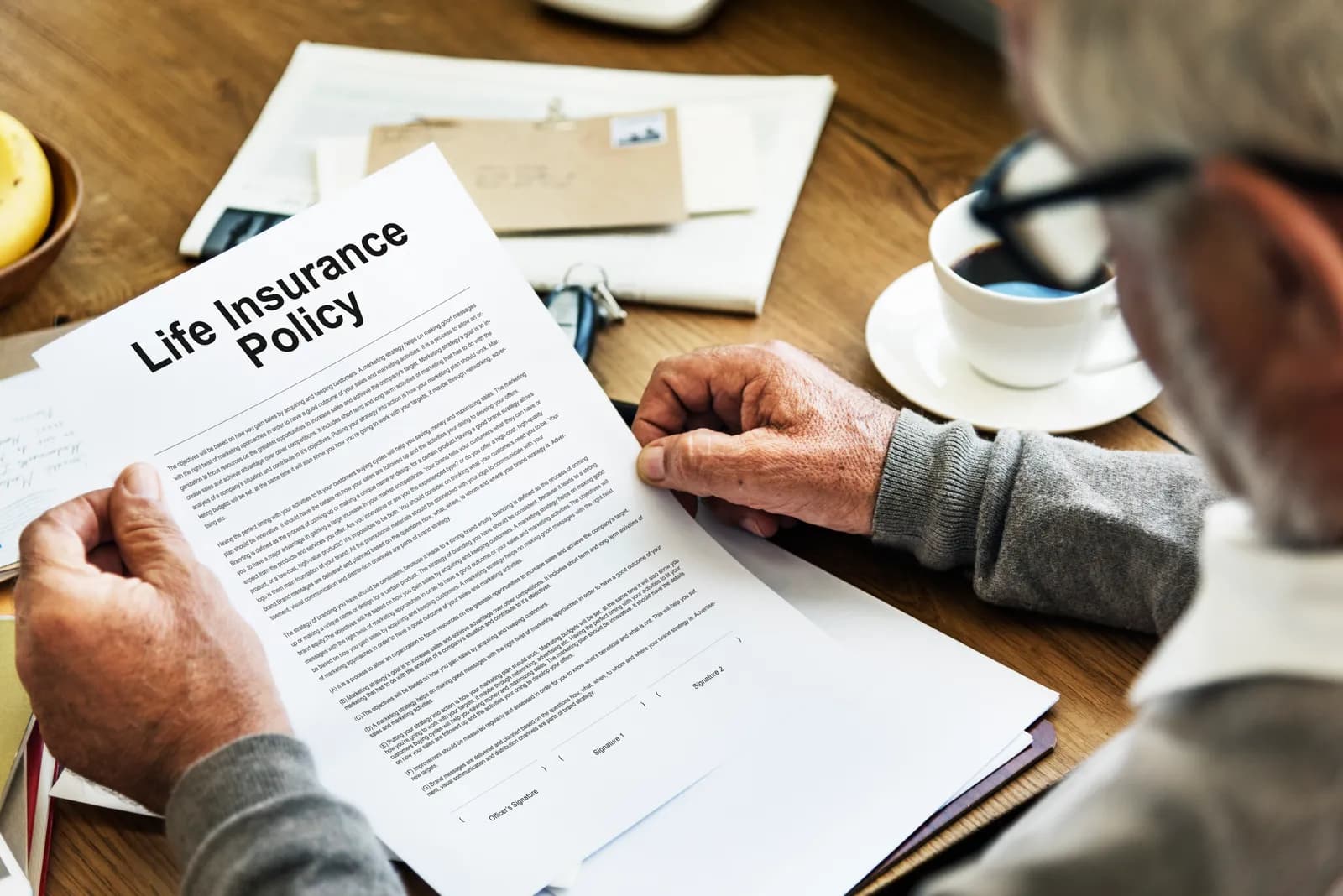A person reviewing a life insurance policy at a table